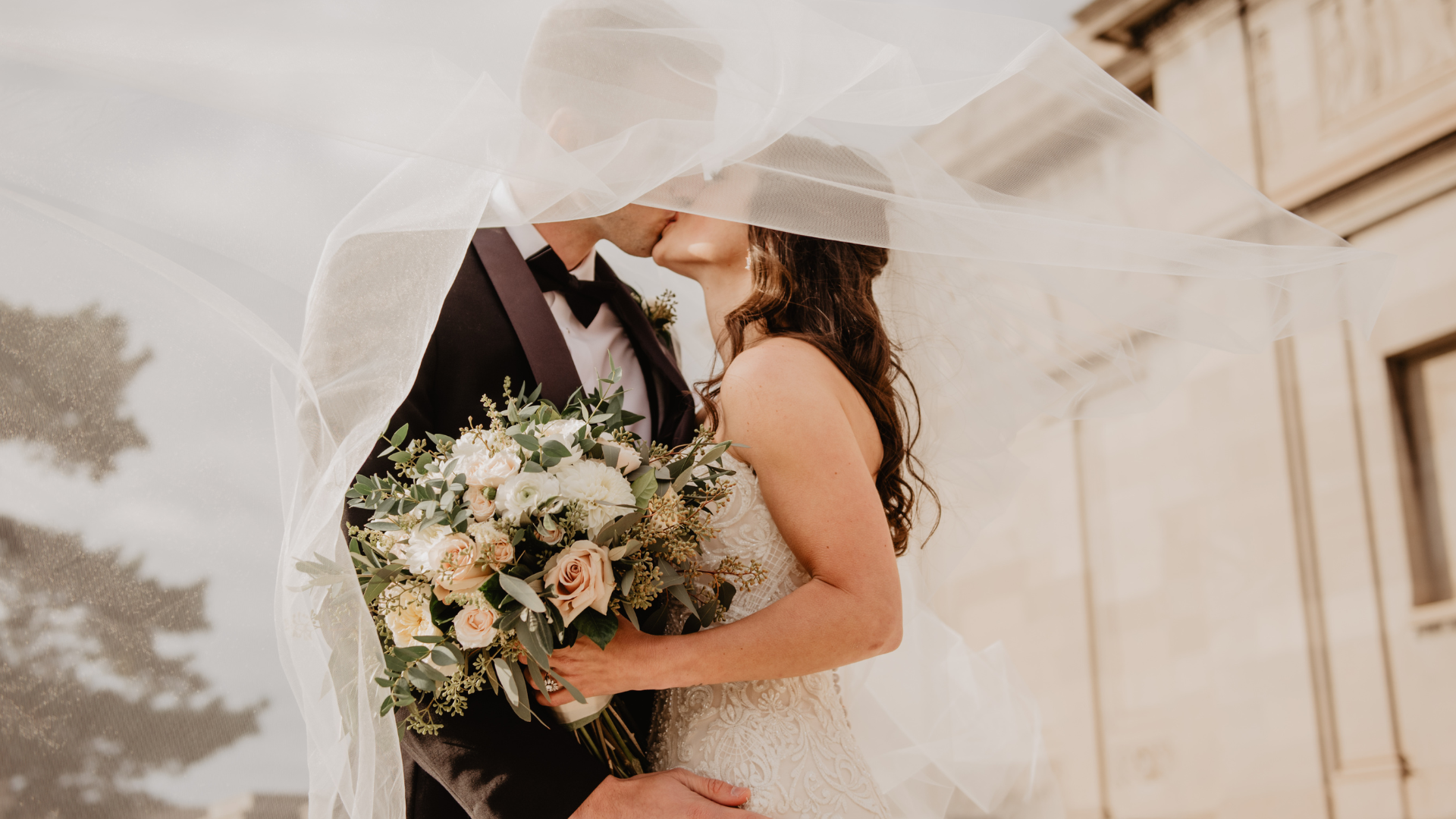Bride and groom under a wedding veil