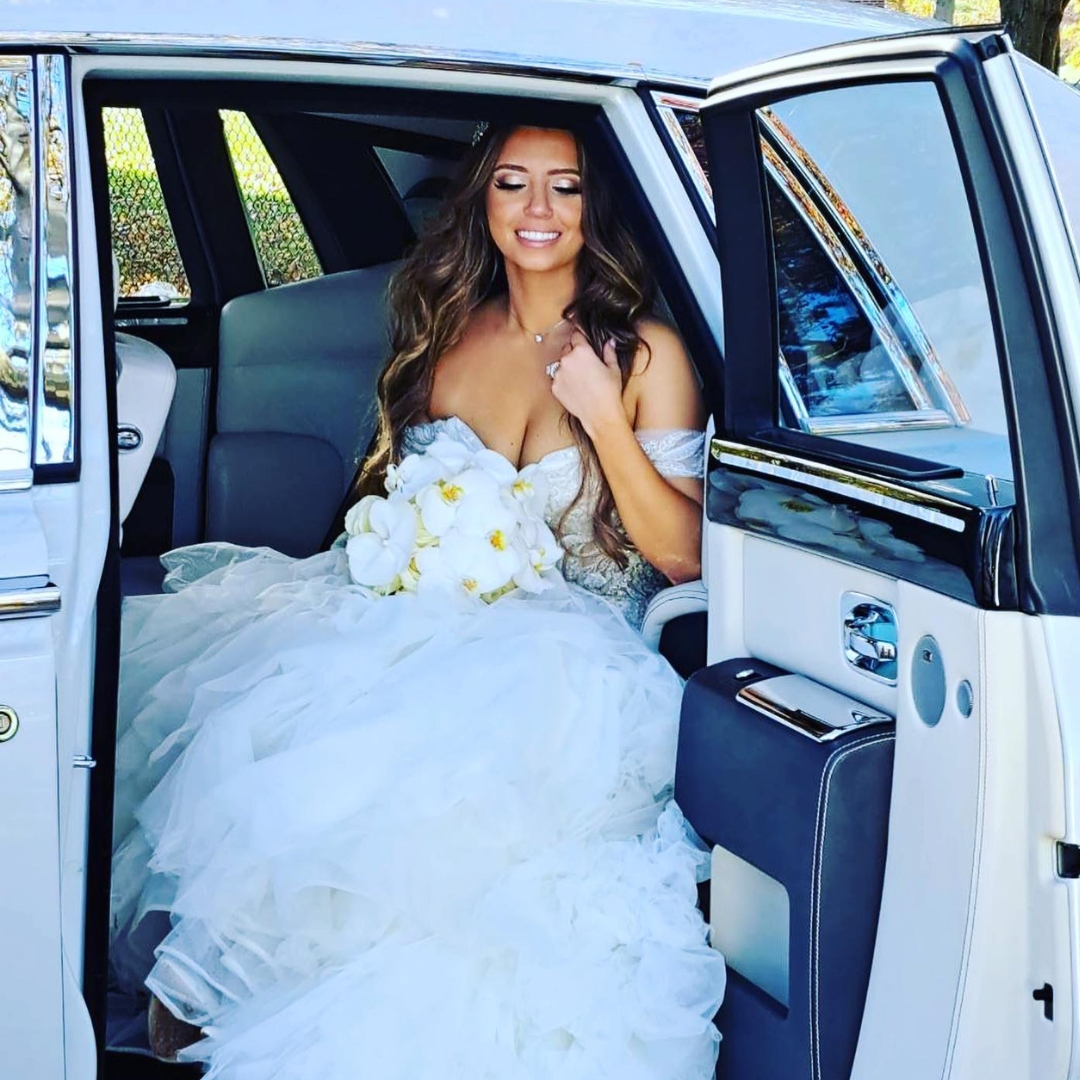 Bride seated inside a luxury wedding car